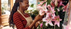 Happy African American woman working at flower shop.